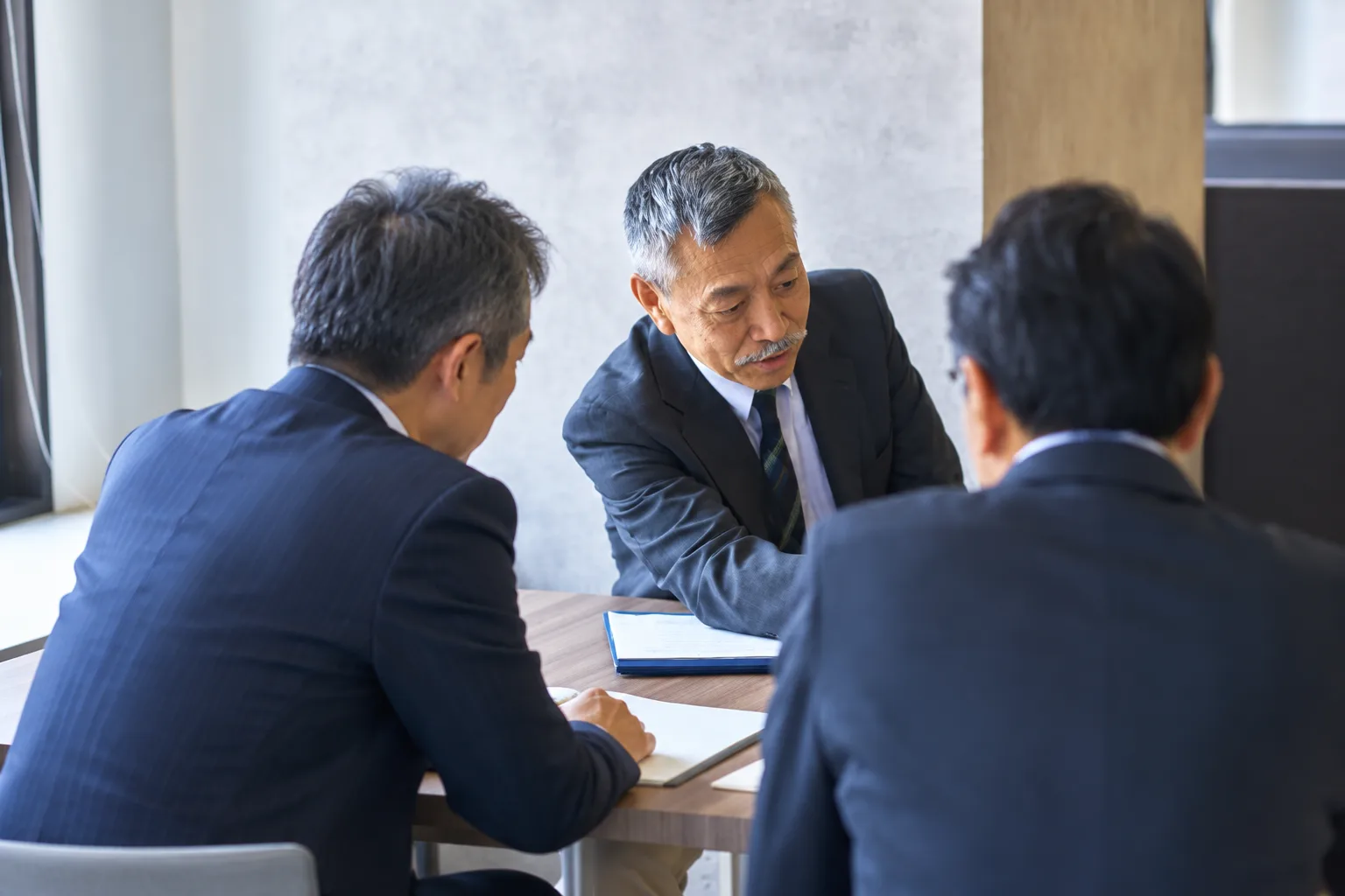 経営者と相談するスタッフ